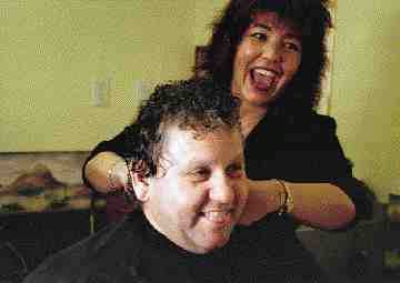Hairdresser Pat Moon and trucker John Valle joke around at Moon Lighting Hair Shop at the 10 Acre Truck Stop in Belleville, Ont.(Photo by Katharina Dillman)