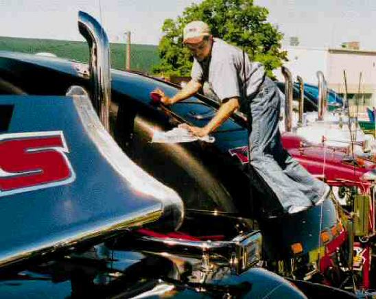 A TSS driver maintains his balance while polishing the raised roof of his sleeper.
