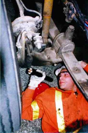 CREEP SHOW: Truck enforcement officer Tony Leitao searches for defects at the Essex South station during RoadCheck 2001. This particular truck passed the inspection with flying colors.
