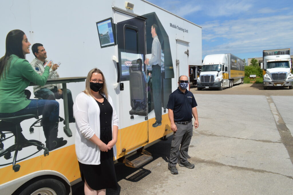 Samantha Clark and Matt Davis with DriveWise's trailer that hauls simulators, in Barrie, Ont. (Photo: Leo Barros)