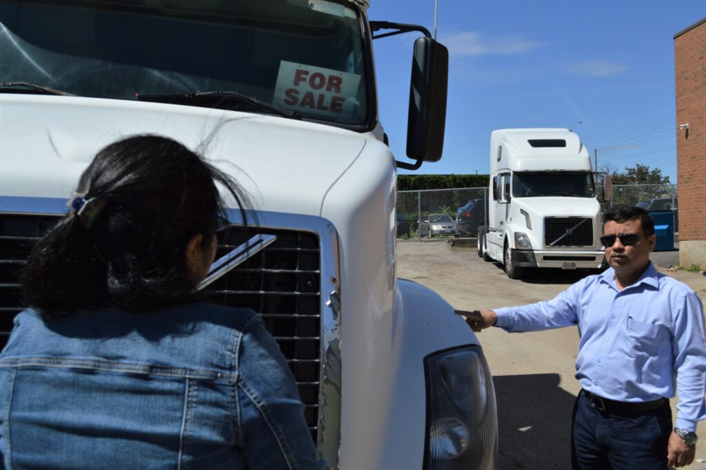 Manjeet Dewan chats with a customer at Diamond Truck Sales in Mississauga, Ont. (Photo: Leo Barros) 