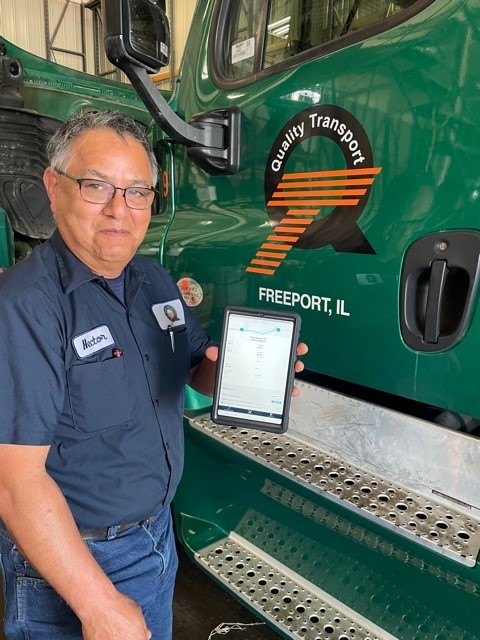 Showing a Quality Transport technician displaying a tablet