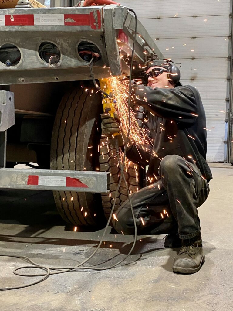 Worker cutting a part on a trailer