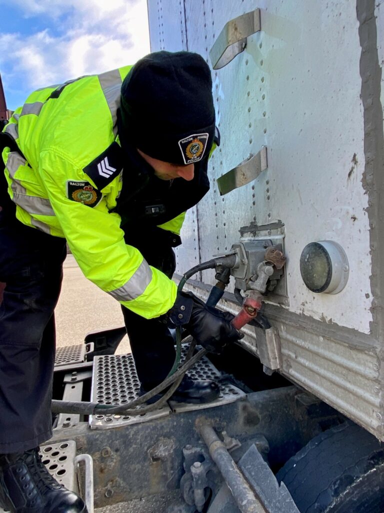 Police officer inspecting a truck