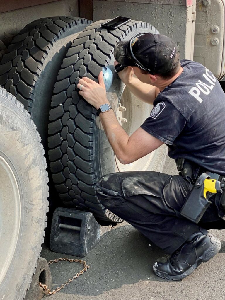 Officer inspecting truck tire