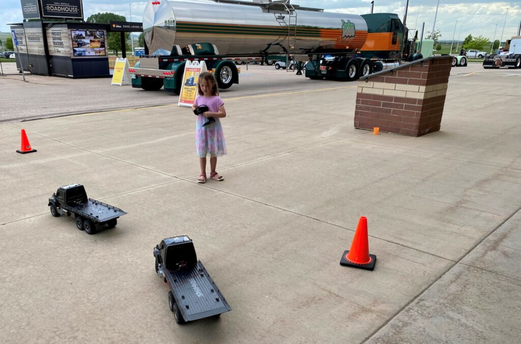 A girl plays with remote-controlled trucks