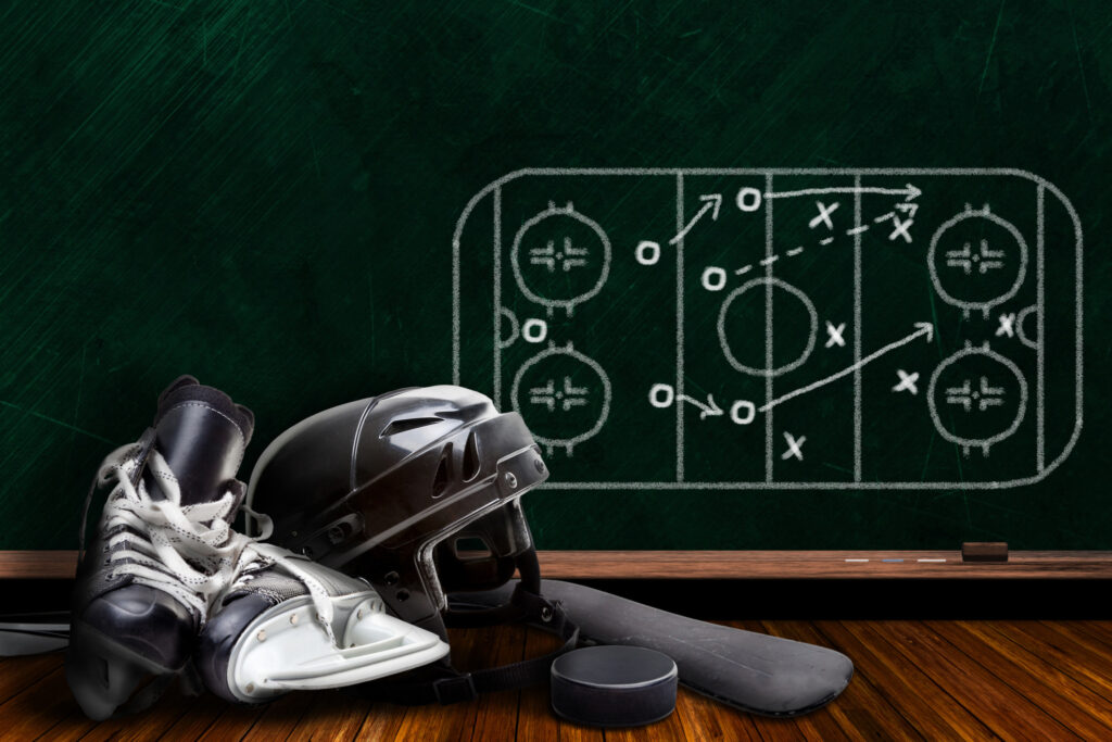 Picture of a strategy board, skates, helmet, puck and hockey stick