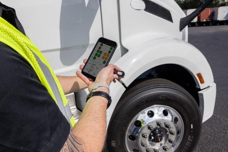 A person monitoring truck tire pressure