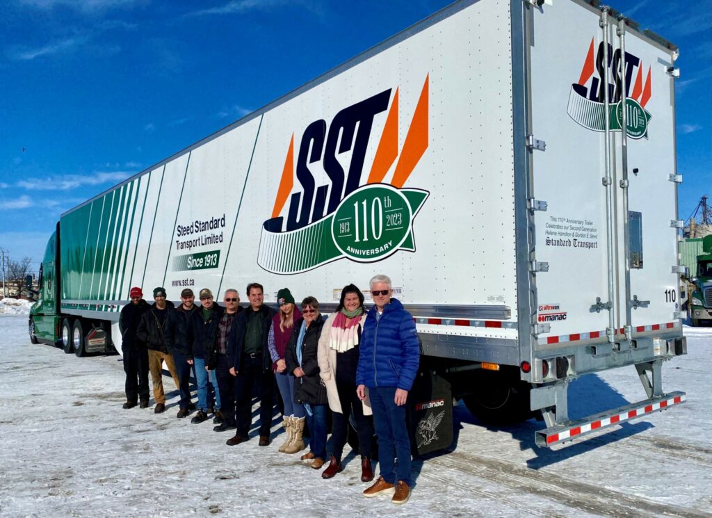 Picture of people standing in front of a SST truck and trailer