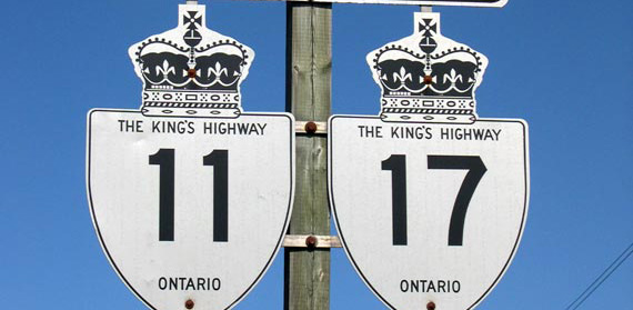 The image is of Highway 11 and 17 signs on a road in a Northern Ontario