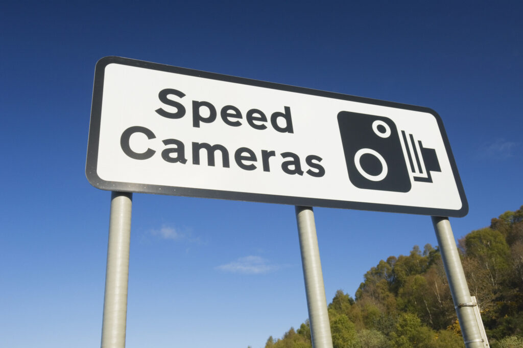 Speed cameras sign against a clear blue sky