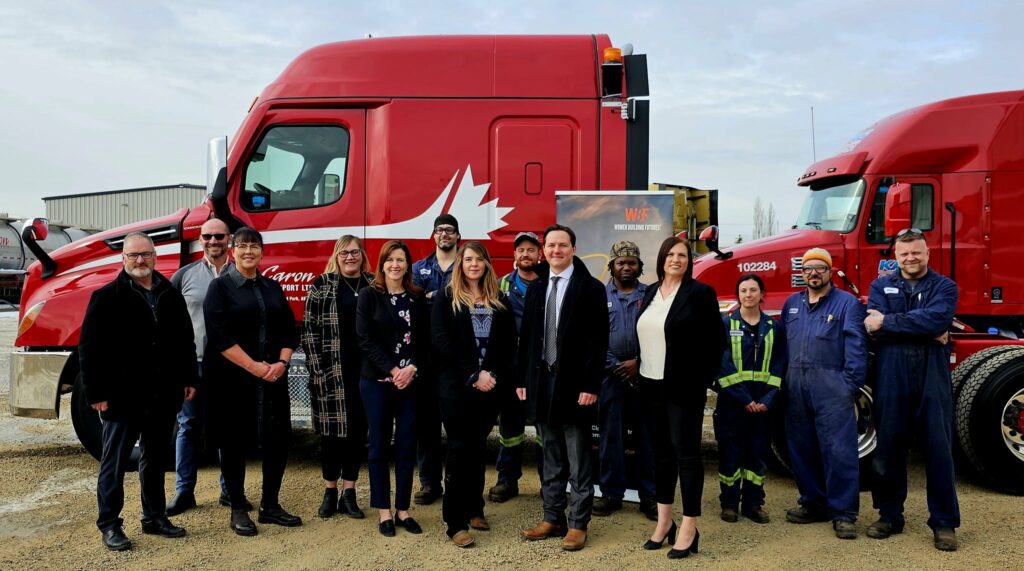 the image is of the government officials in front of the red truck on the day of the grant announcement