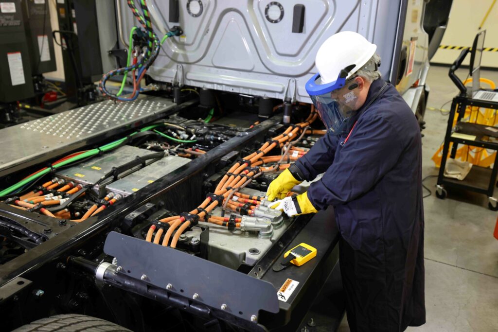The image shows a person working on the battery electric truck