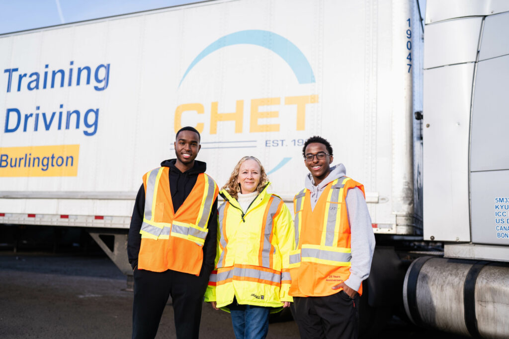 Three people in front of CHET-branded trailer