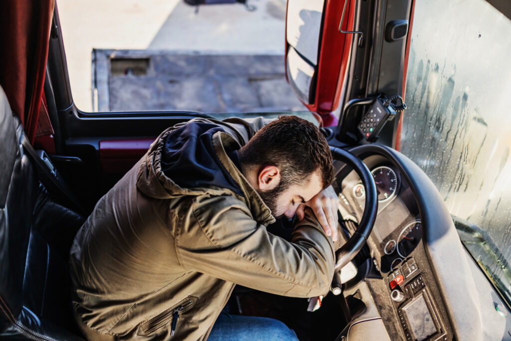 Tired driver sleeps in the cab of his truck.