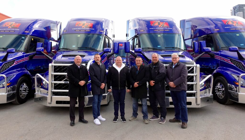 A group of men standing in front of a truck  